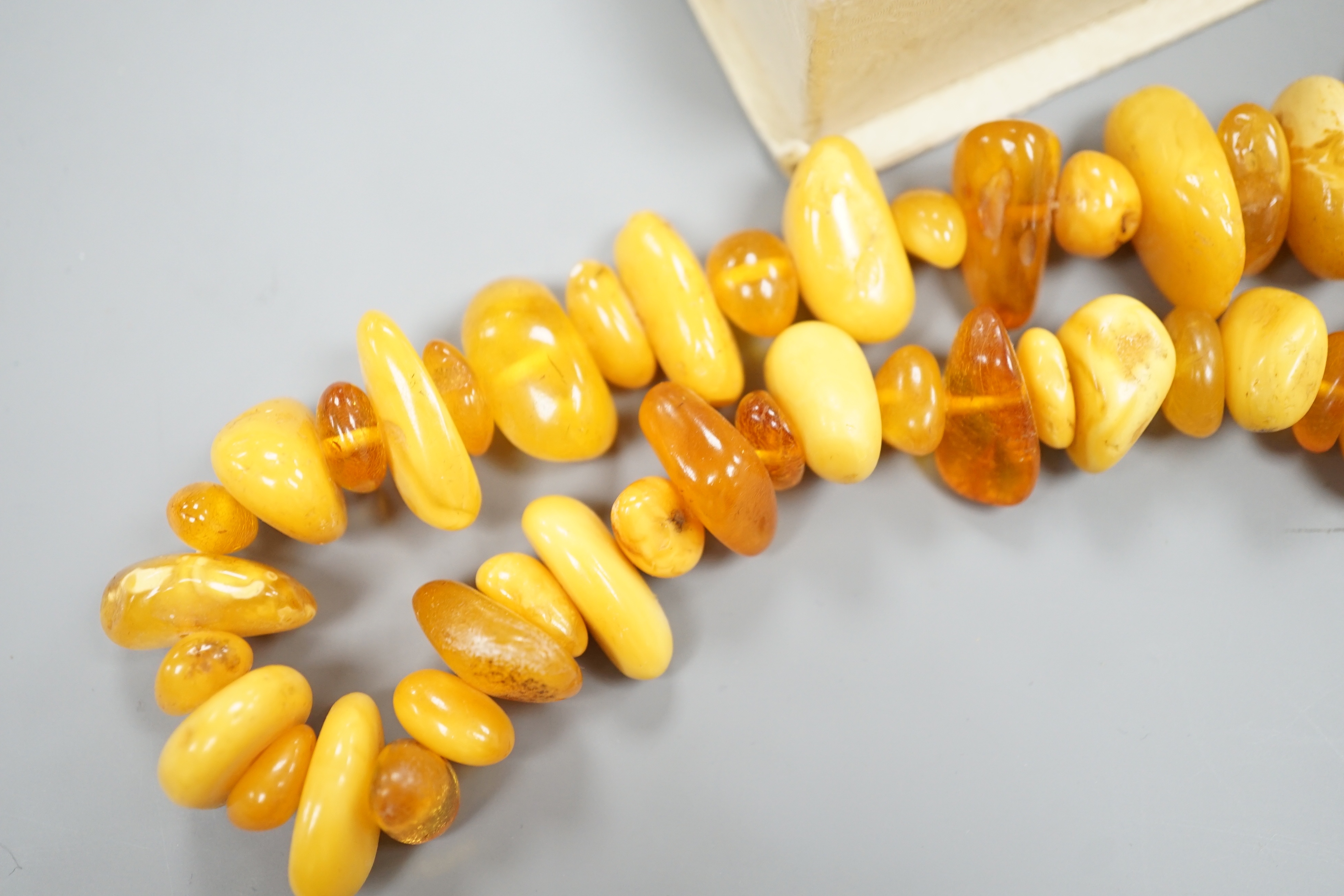 An amber bead necklace, gross 72 grams and a costume bracelet and earclips.